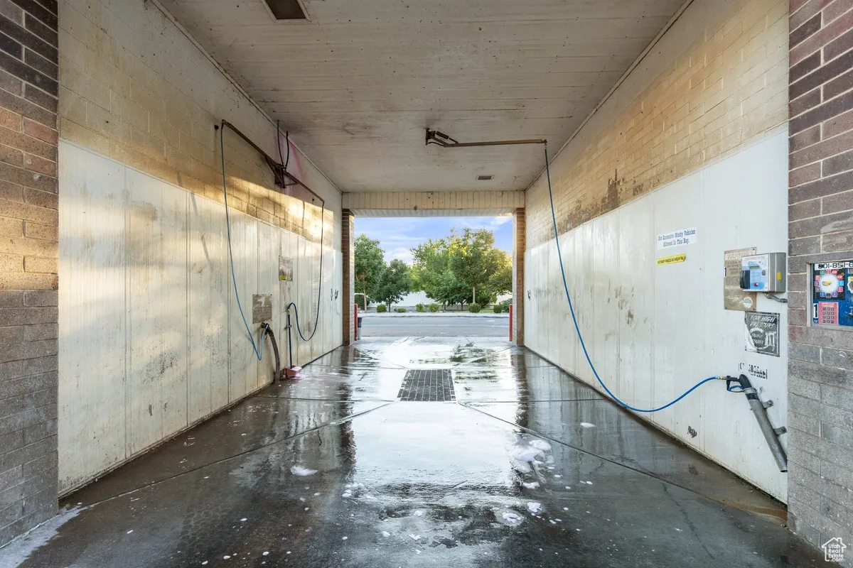 Miscellaneous room with brick wall and concrete floors