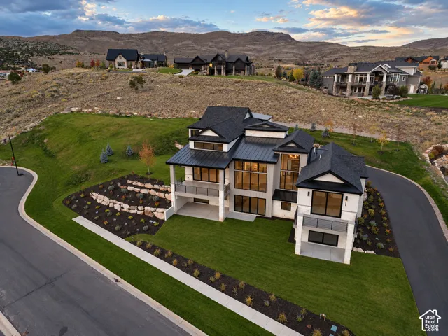 Modern-style residence featuring a multi-level design, white exterior cladding, and expansive black-framed windows