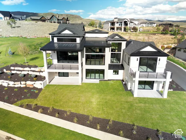 Contemporary exterior with multiple balconies, a finished walk-out lower level, and a multi-level roofline
