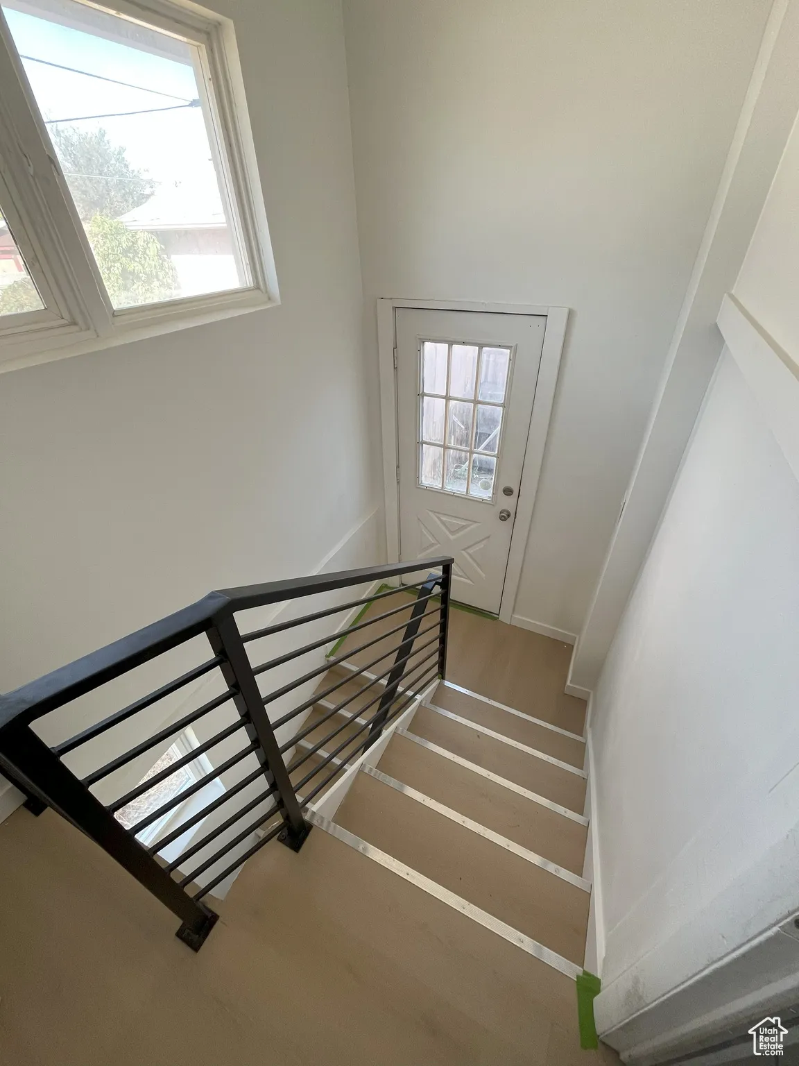 Staircase with plenty of natural light and wood finished floors