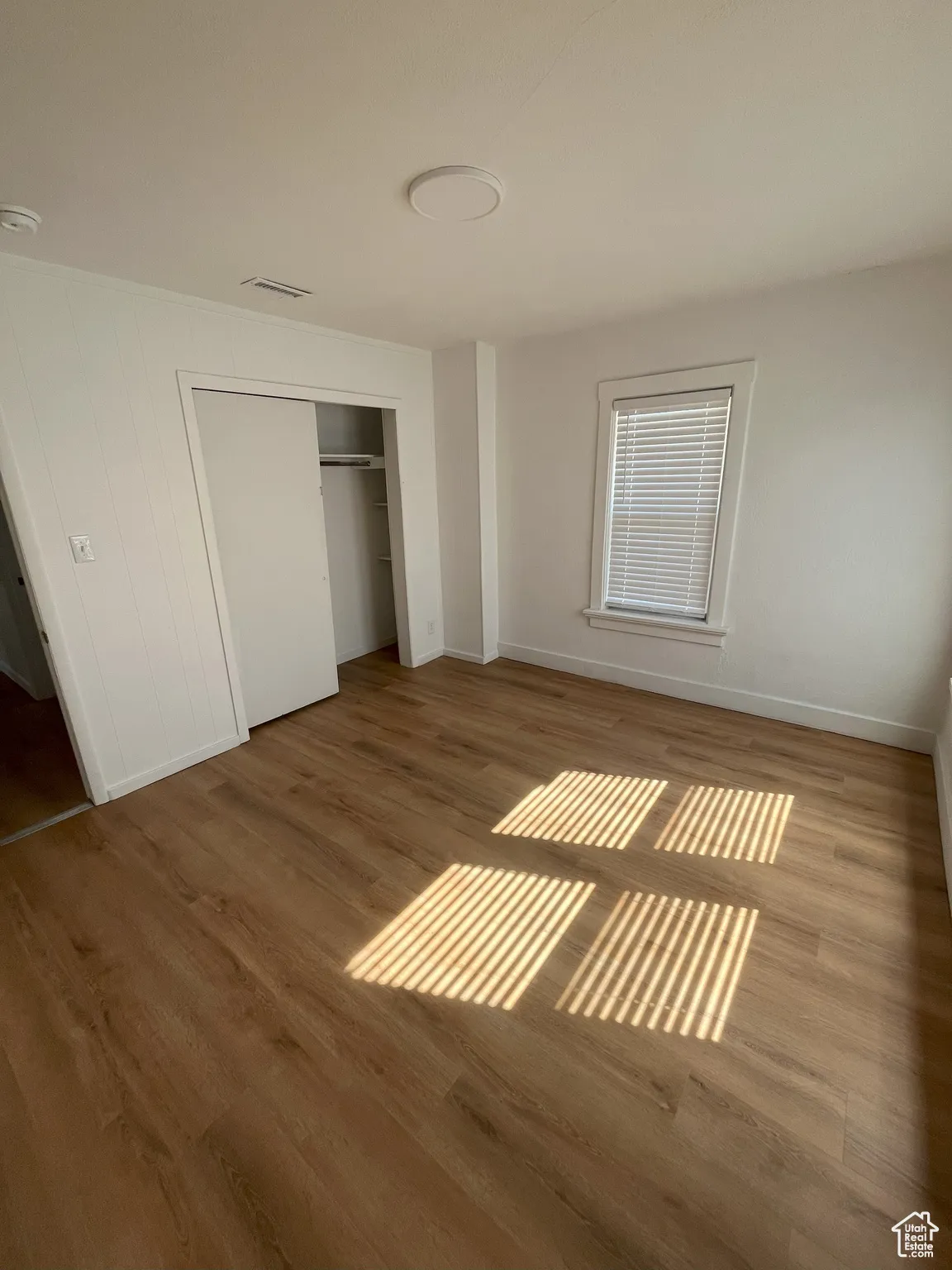 Unfurnished bedroom with a closet and wood finished floors
