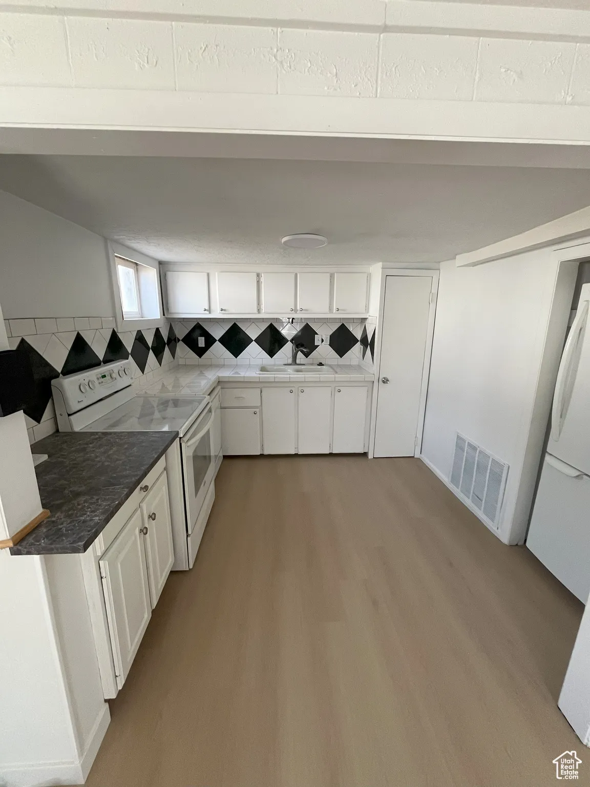 Washroom with light wood-style floors and a sink