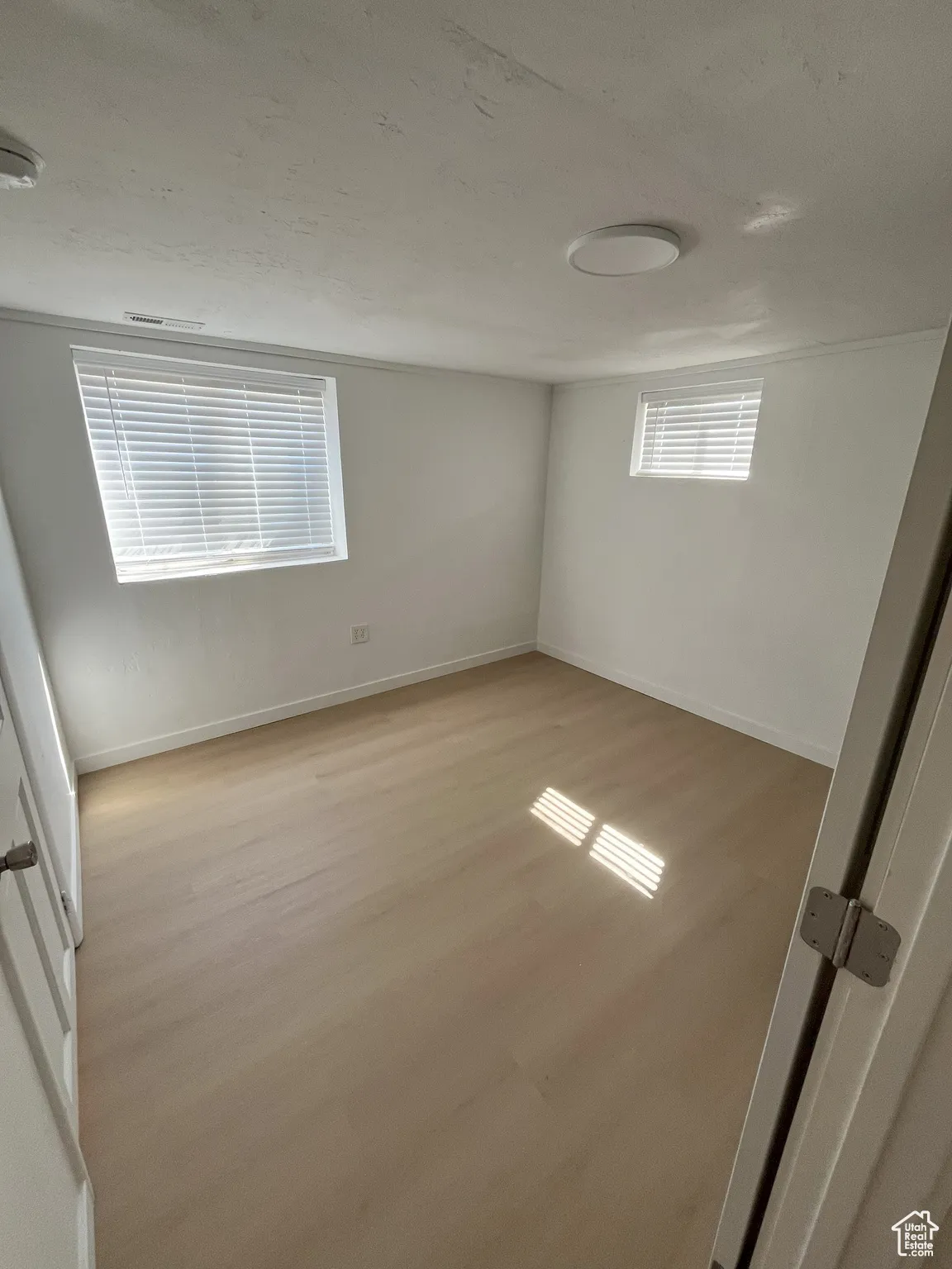 Unfurnished bedroom featuring light wood finished floors and a textured ceiling