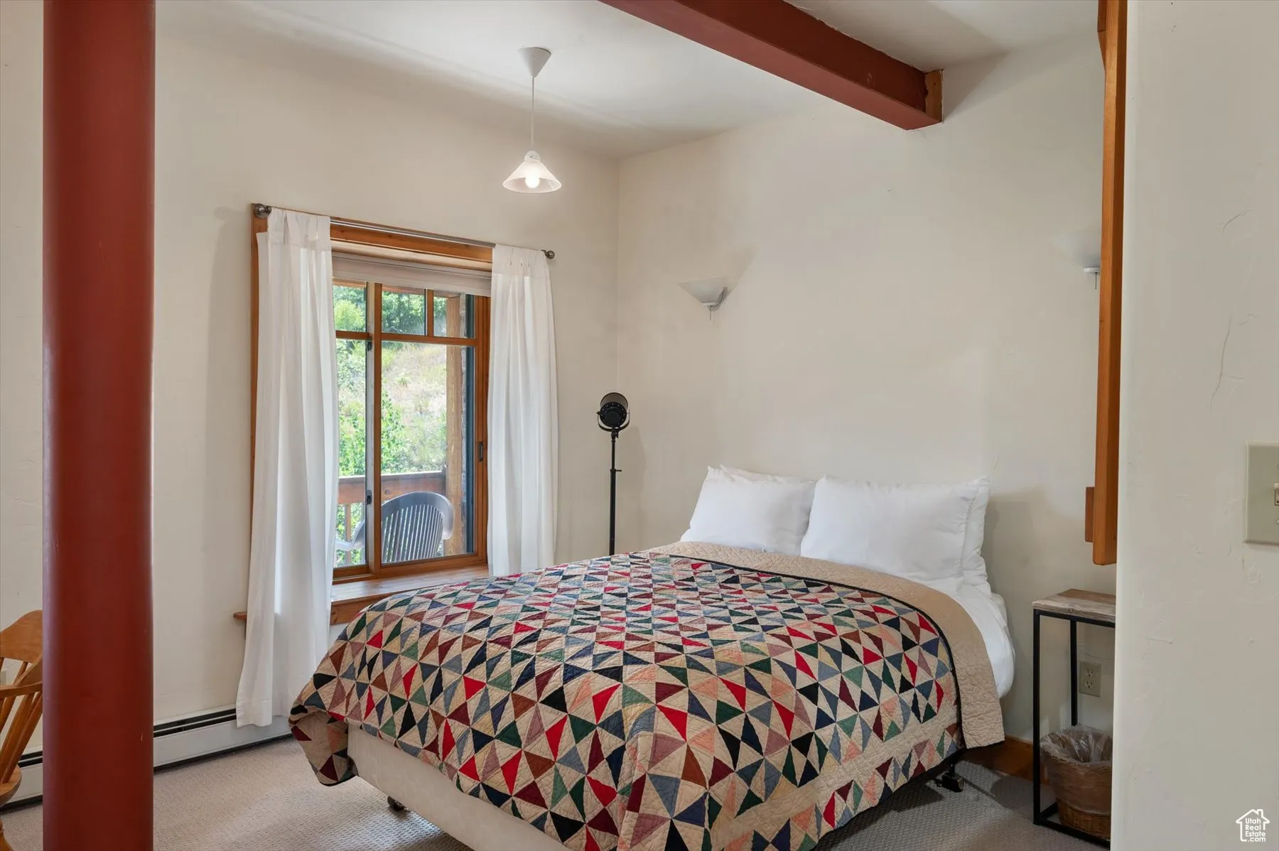 Bedroom featuring carpet, beamed ceiling, in the studio apartment