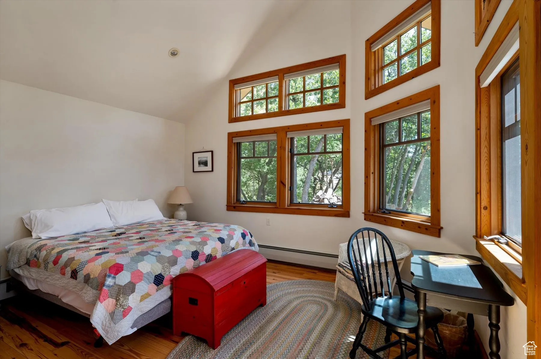 Primary suite with vaulted ceilings, numerous windows offering wonderful views, French doors leading out to a covered deck and access to a full bath