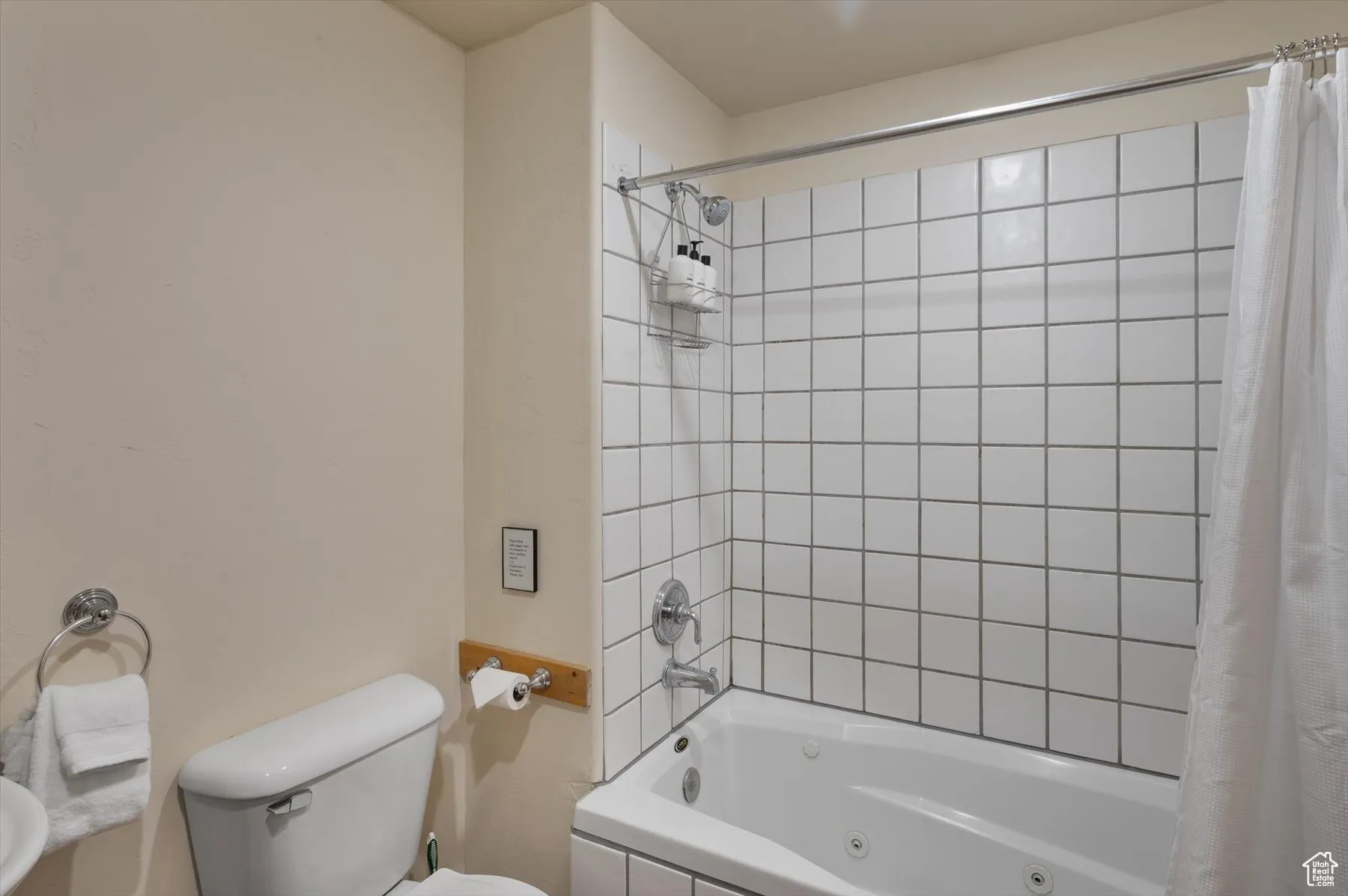 Bathroom with toilet and a combined bath / shower with jetted tub in the apartment