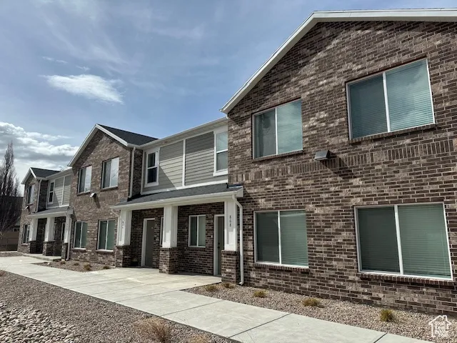 View of front of home featuring brick siding and covered porch