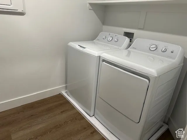 Washroom featuring dark wood-style flooring and washer and clothes dryer