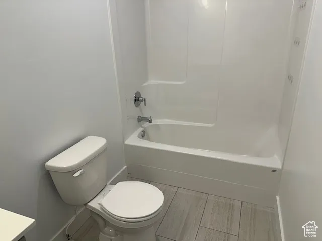 Bathroom with washtub / shower combination, vanity, and light wood-type flooring