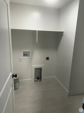 Laundry room featuring electric dryer hookup, hookup for a washing machine, and light tile patterned floors