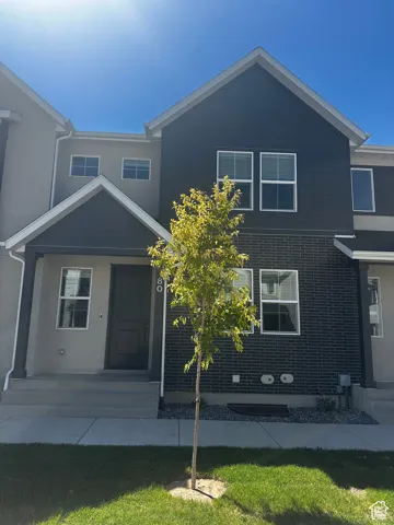 View of front of home featuring a front yard, a porch, and stucco siding