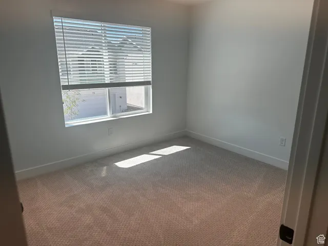 Carpeted empty room with baseboards