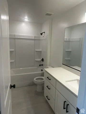 Bathroom featuring shower / washtub combination, vanity, and light tile patterned flooring