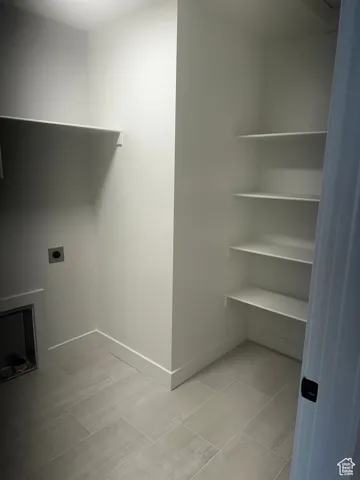 Laundry room featuring hookup for an electric dryer and light tile patterned floors