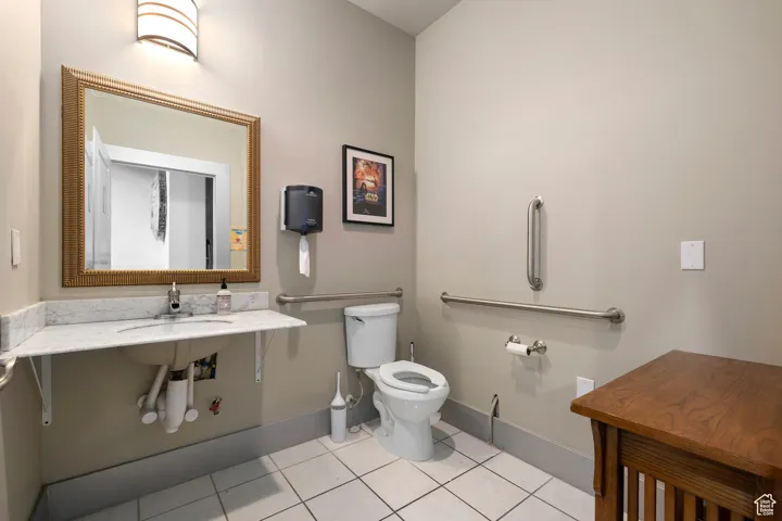 Bathroom with toilet and light tile patterned floors