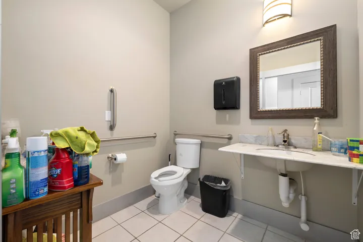 Half bathroom featuring toilet and light tile patterned floors