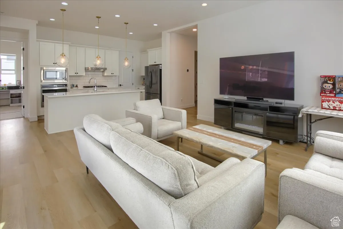 Living area featuring light wood-type flooring and recessed lighting