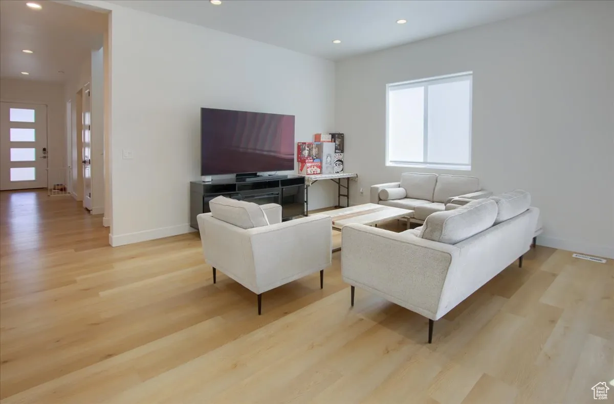 Living area featuring light wood-style flooring and recessed lighting