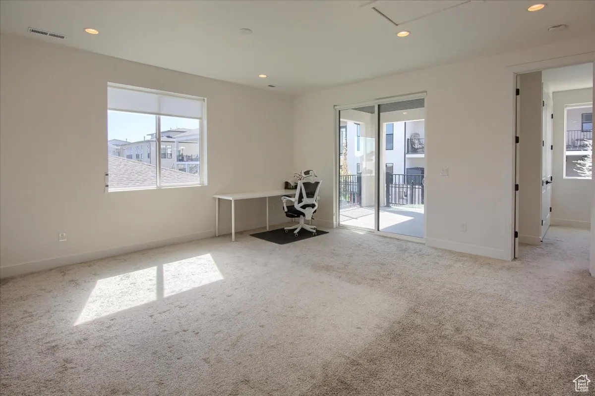 Carpeted empty room with recessed lighting and healthy amount of natural light