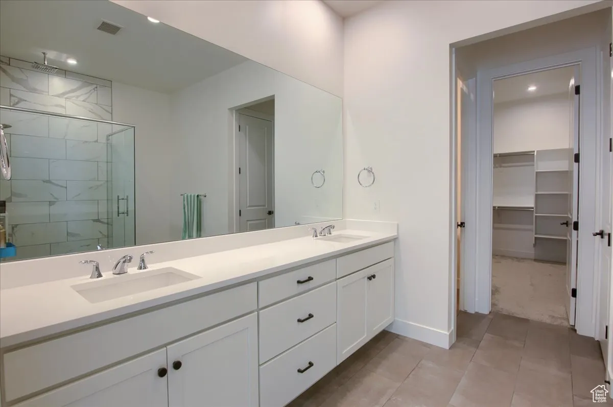 Full bath with a shower stall, a walk in closet, recessed lighting, and light tile patterned flooring