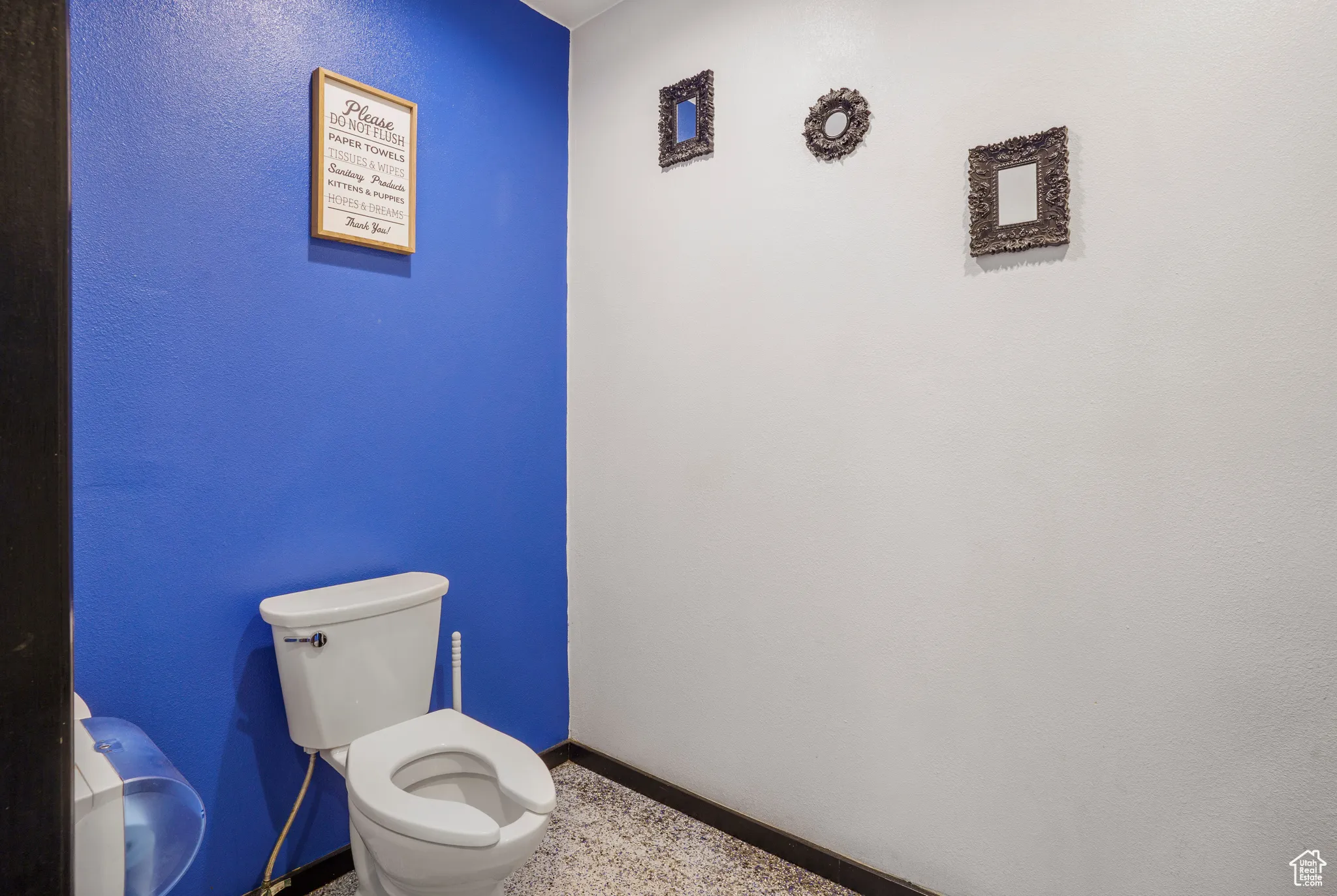 Half bath with toilet and speckle patterned floor
