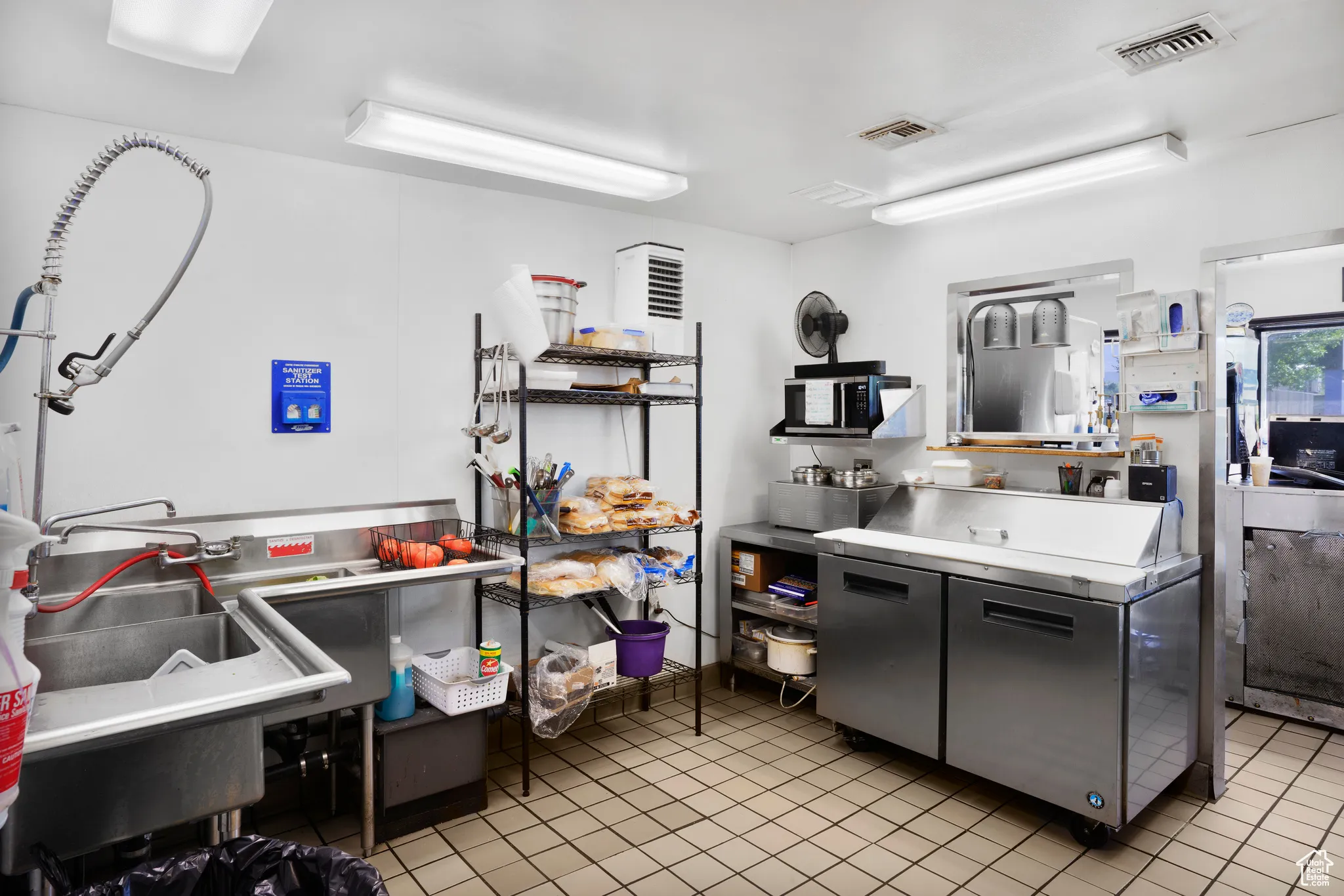 Kitchen with light tile patterned flooring and stainless steel counters
