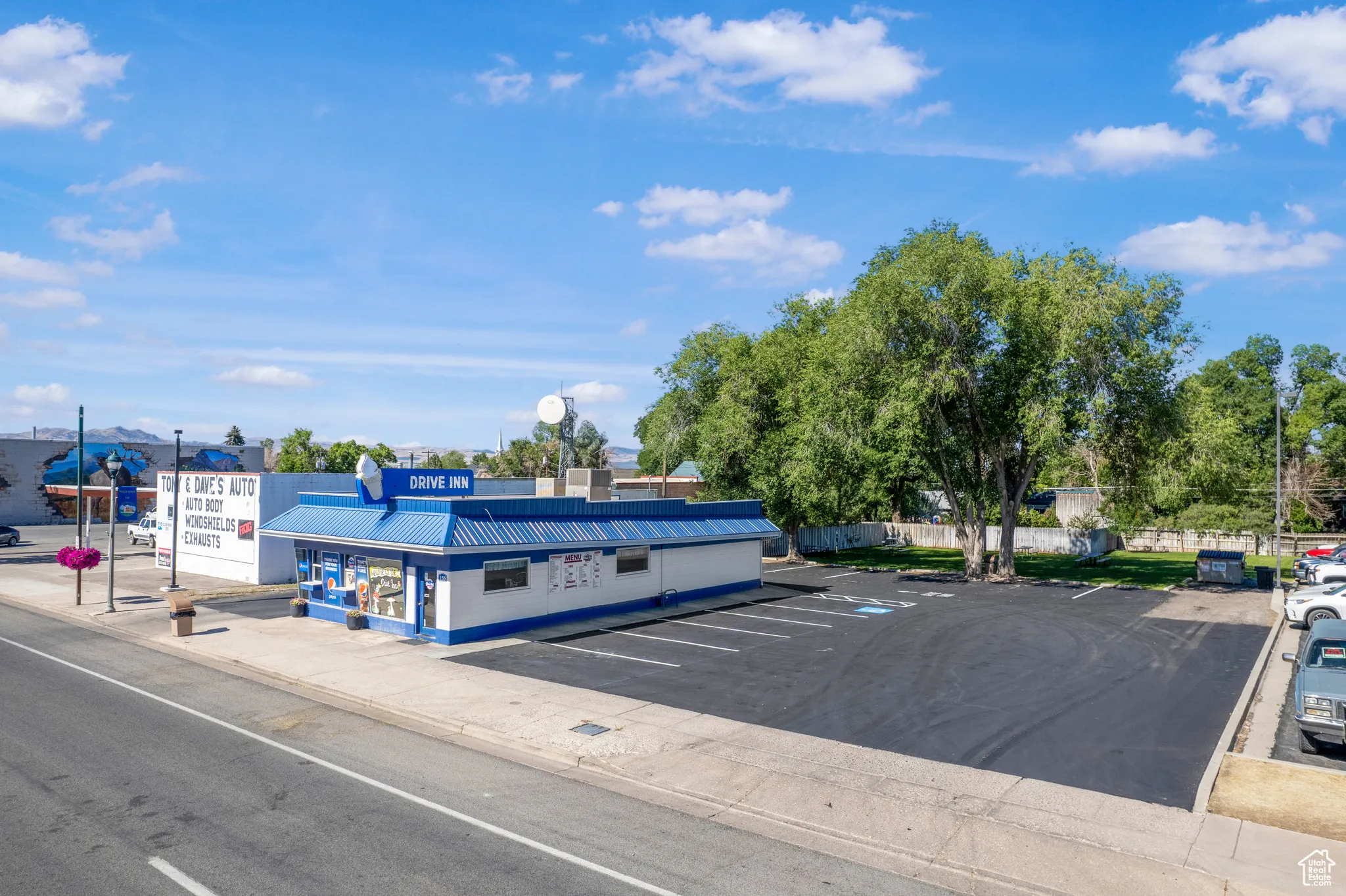 View of asphalt street featuring curbs and street lighting