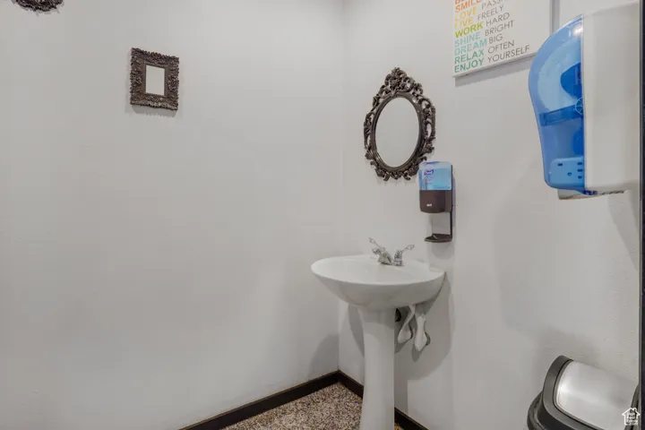 Bathroom with baseboards and speckle patterned floor