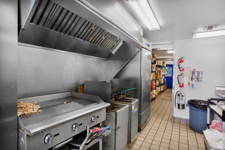 Kitchen with premium range hood and light tile patterned flooring