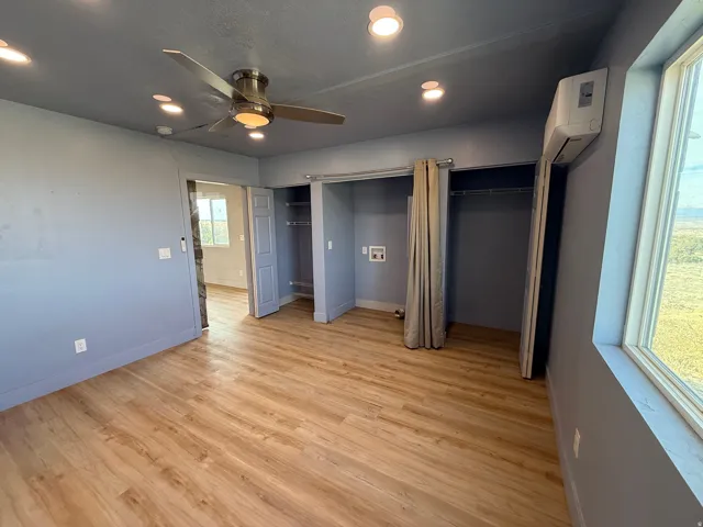 Unfurnished bedroom with two closets, recessed lighting, light wood finished floors, and a ceiling fan