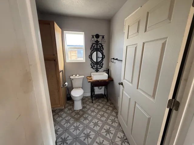 Half bathroom with light flooring and a textured ceiling