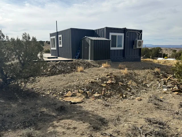 View of property exterior featuring board and batten siding and an ac unit