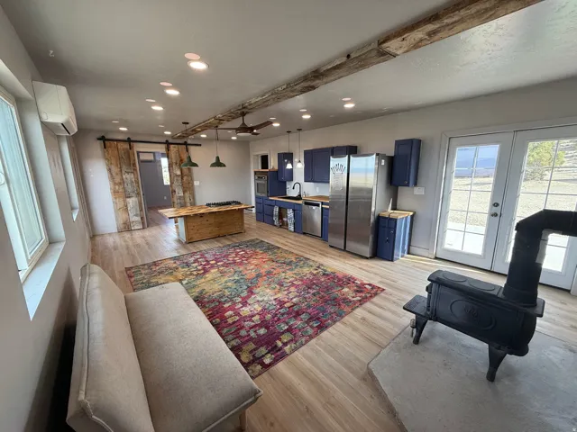 Living area featuring a barn door, light wood finished floors, recessed lighting, and french doors