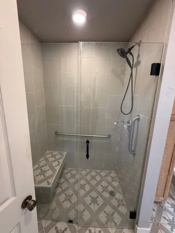 Full bath featuring a stall shower and light tile patterned floors
