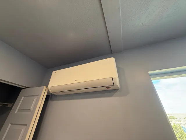 Detailed view of a wall mounted mini split and a textured ceiling