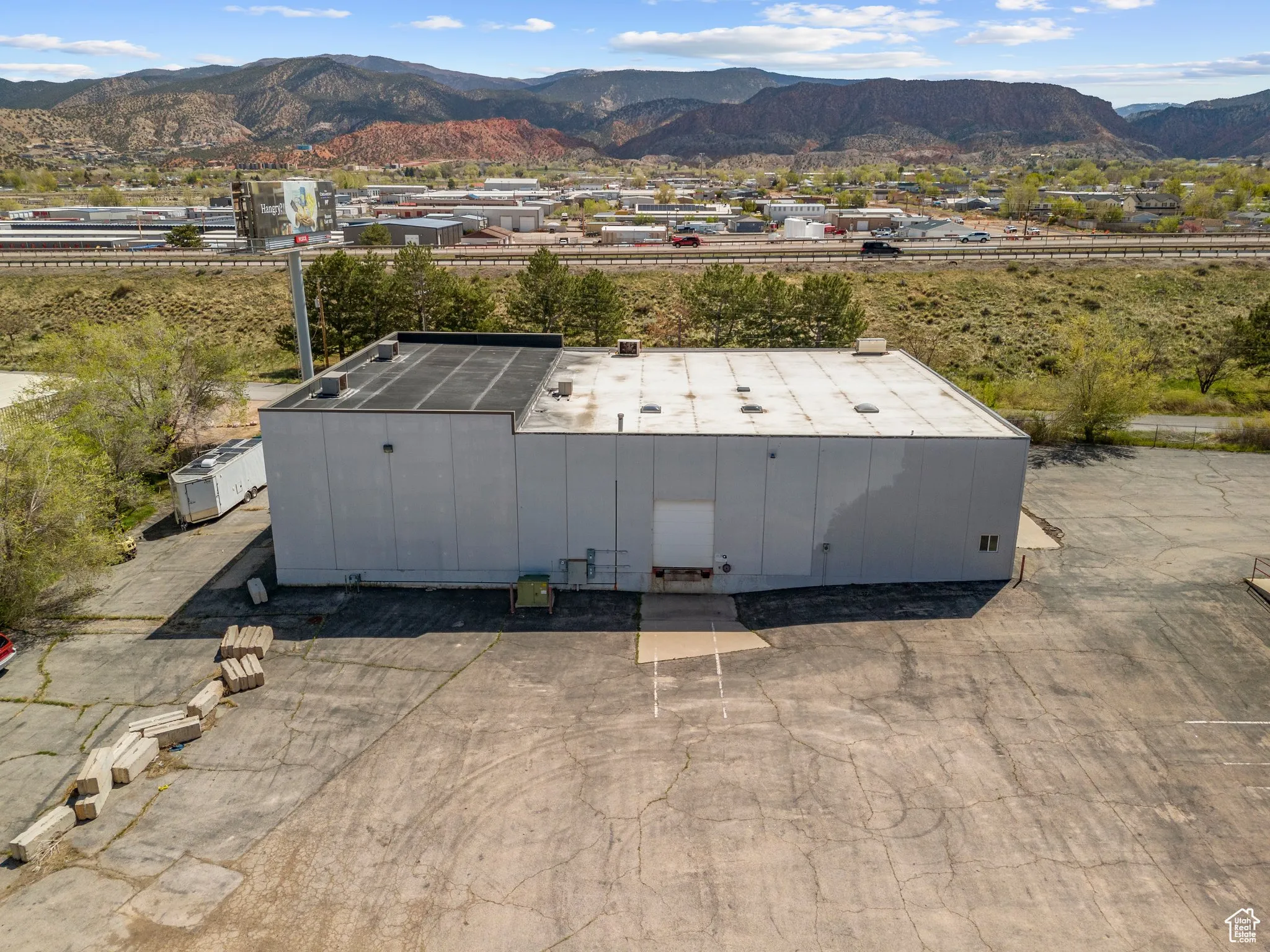 Aerial view of property and surrounding area featuring a mountain backdrop