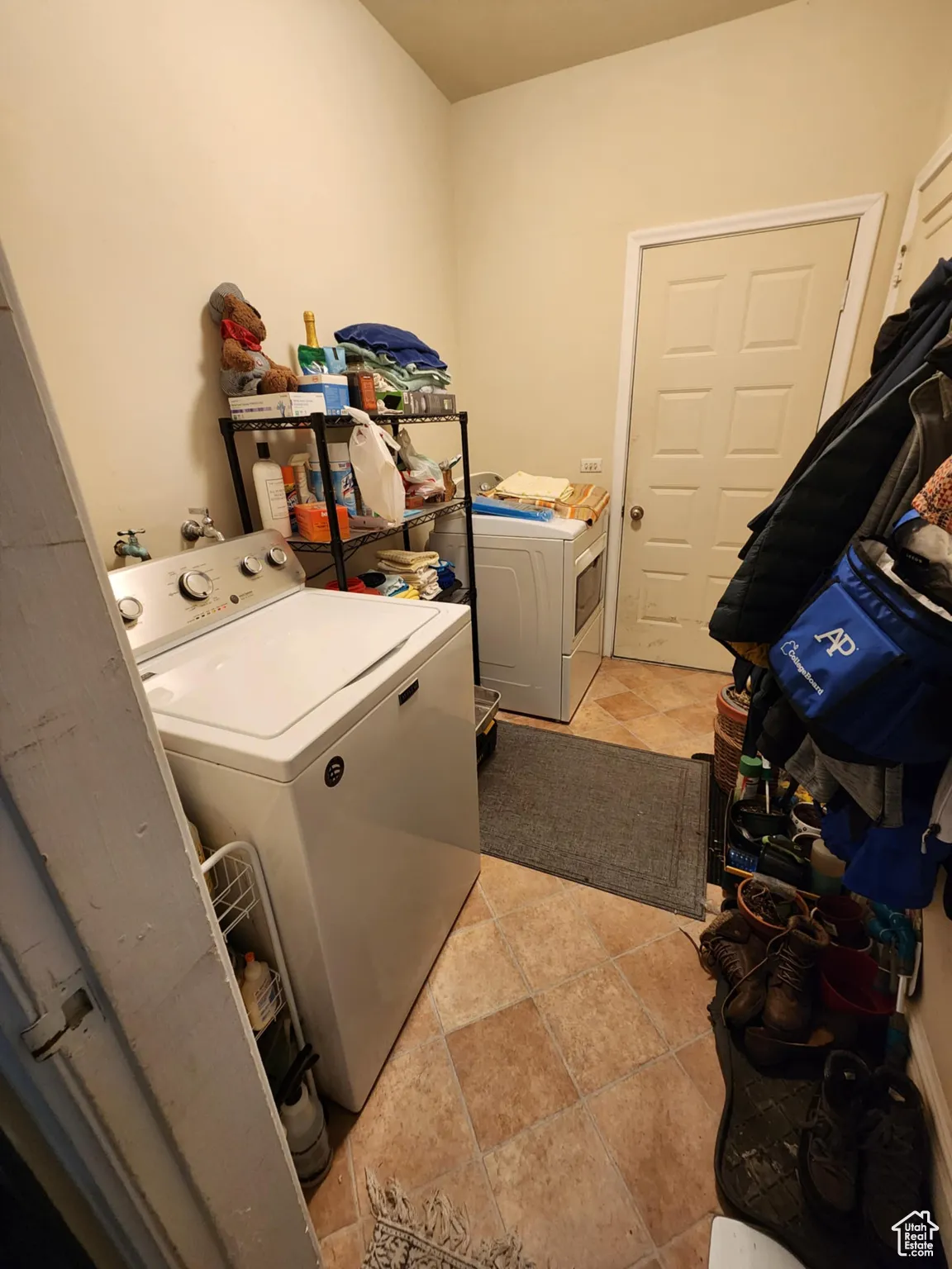 Laundry room featuring independent washer and dryer and light tile patterned flooring