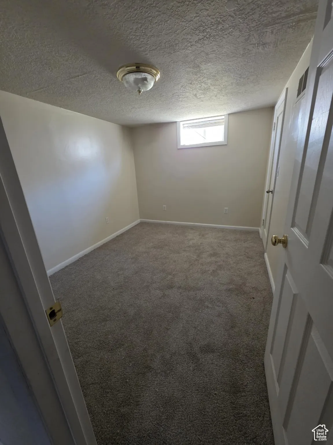 Unfurnished bedroom featuring carpet flooring and a textured ceiling