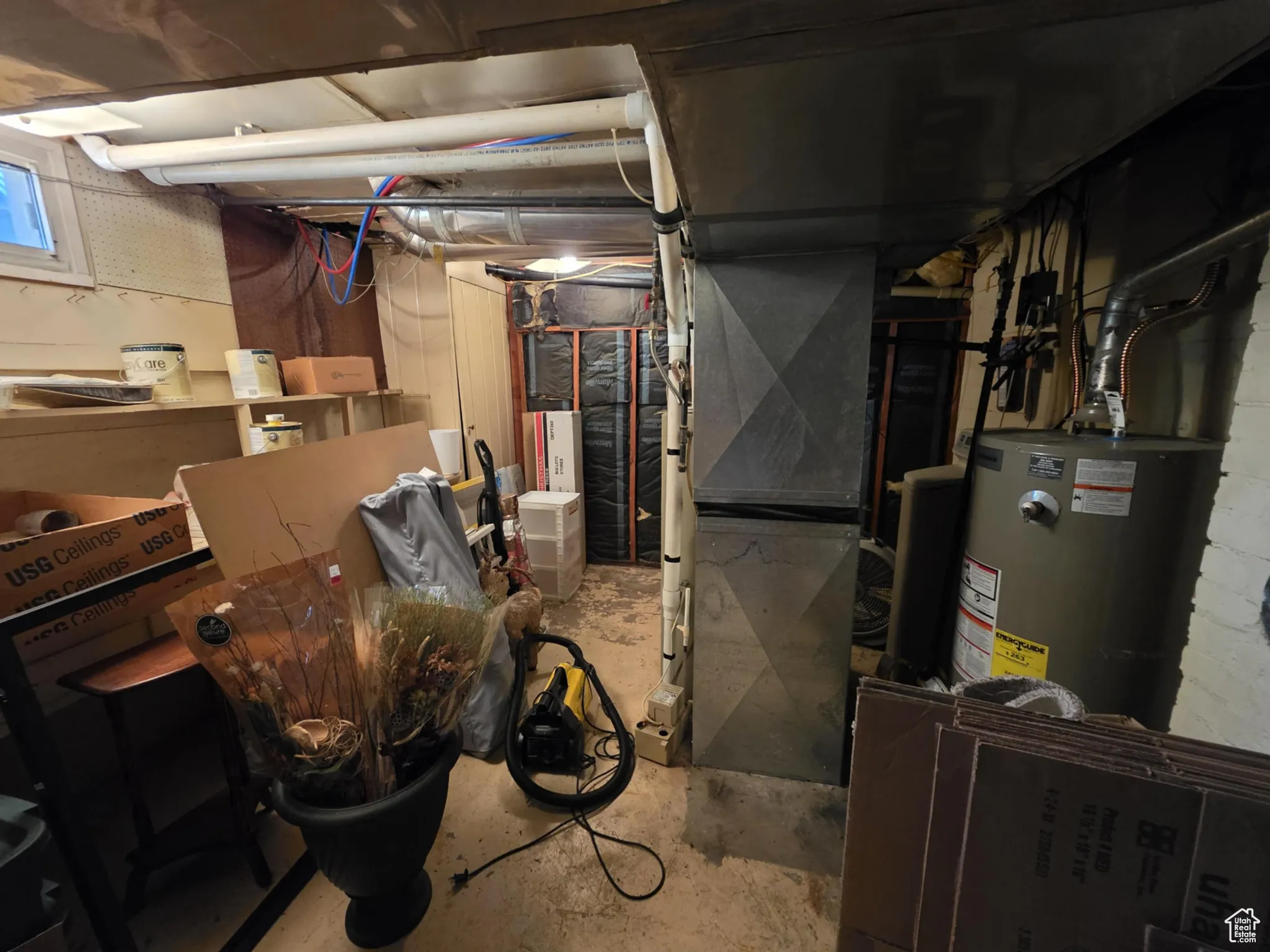 Unfinished basement featuring heating unit and gas water heater