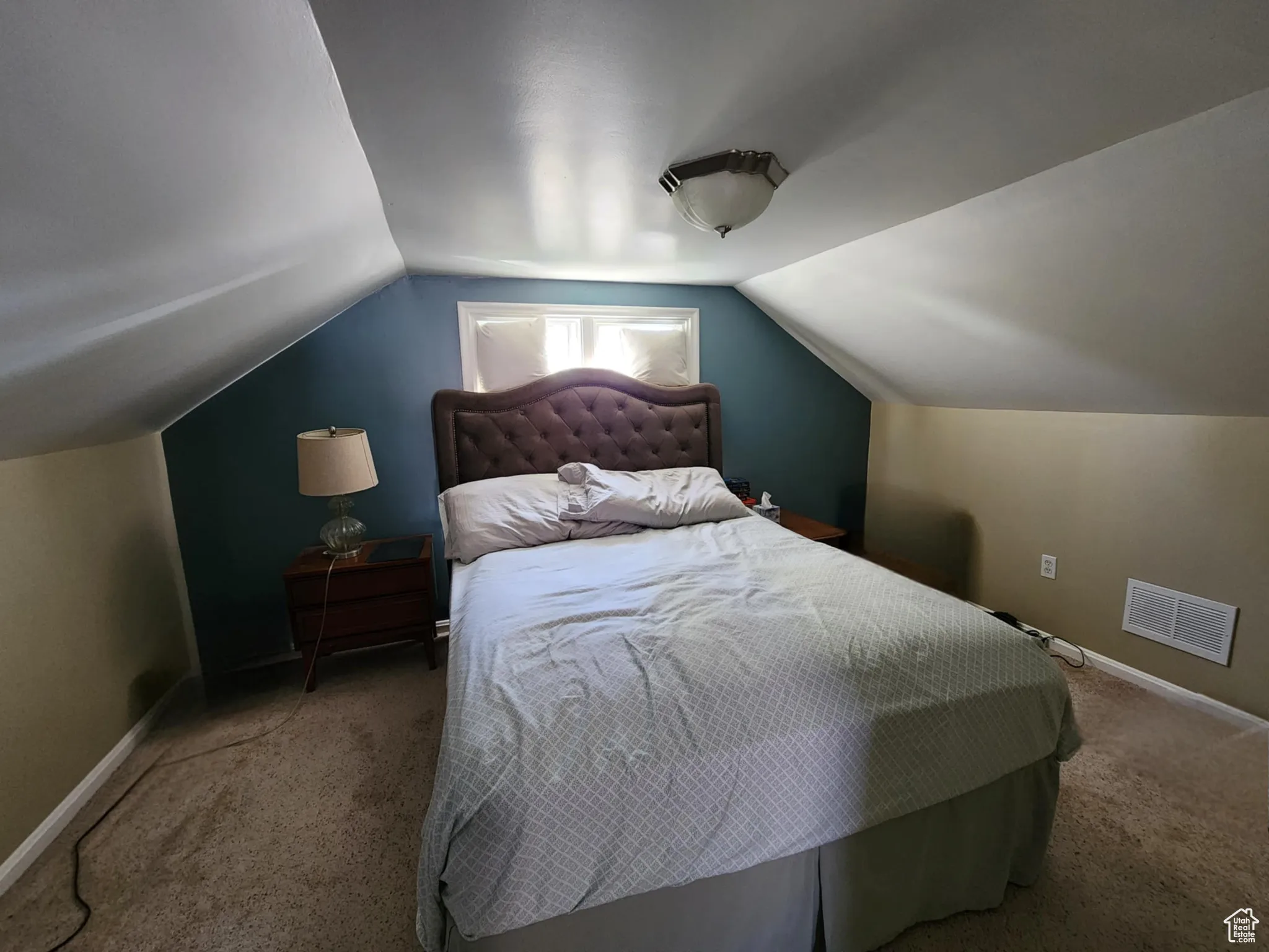 Bedroom featuring carpet and vaulted ceiling