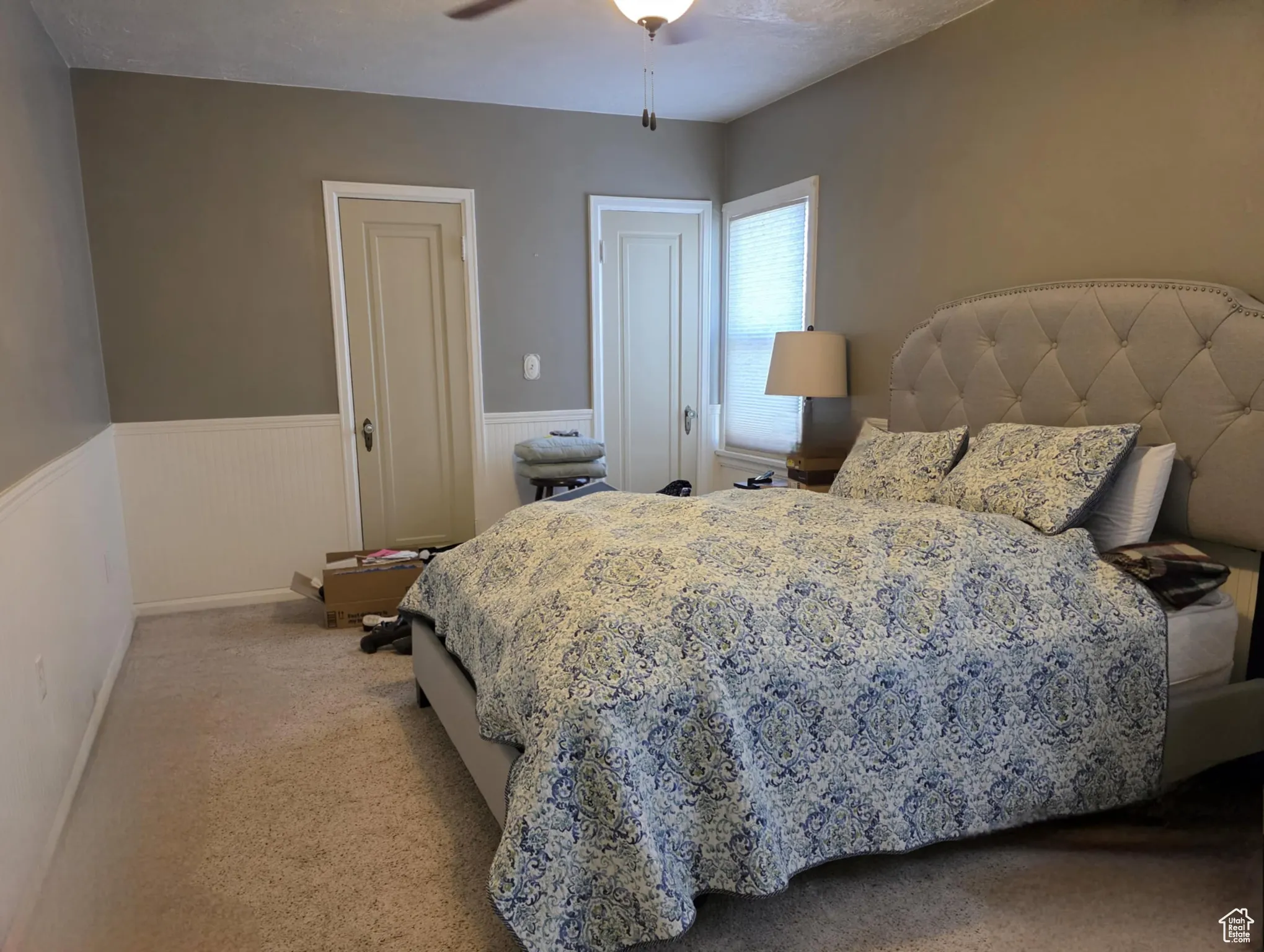 Bedroom with wainscoting, light carpet, and ceiling fan