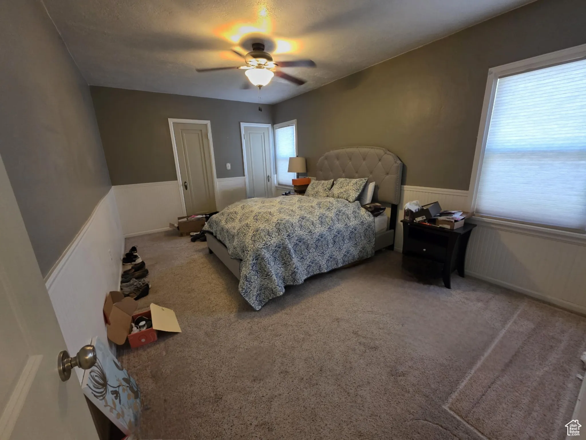 Carpeted bedroom featuring wainscoting, a ceiling fan, and a textured ceiling