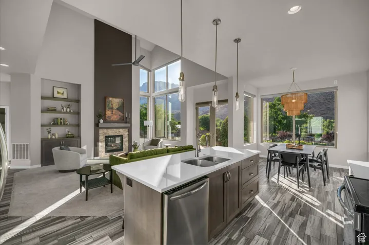 Kitchen with stainless steel dishwasher, electric range, a fireplace, recessed lighting, and decorative light fixtures