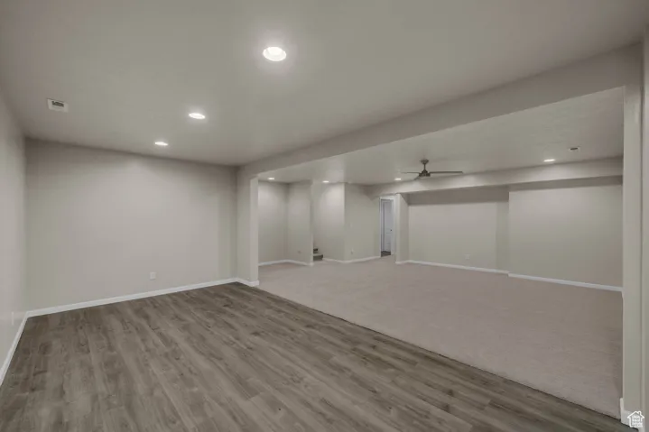 Finished basement with ceiling fan, recessed lighting, and light wood finished floors