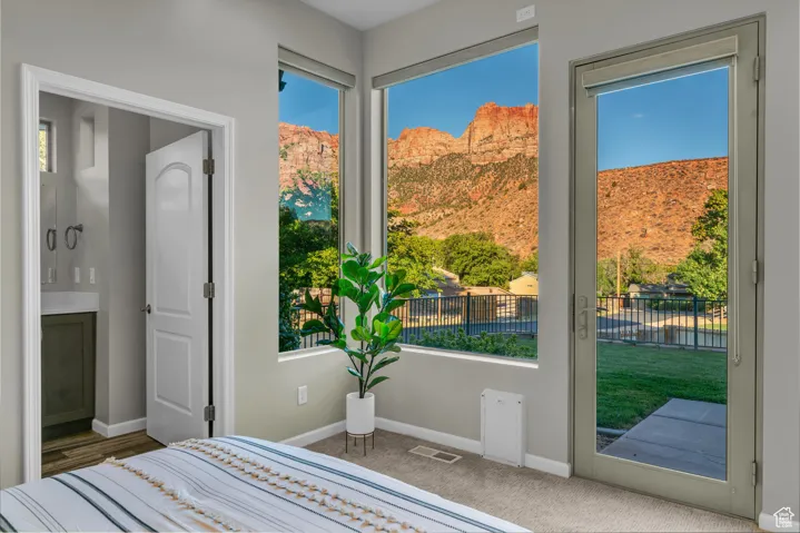 Carpeted bedroom featuring baseboards and access to outside
