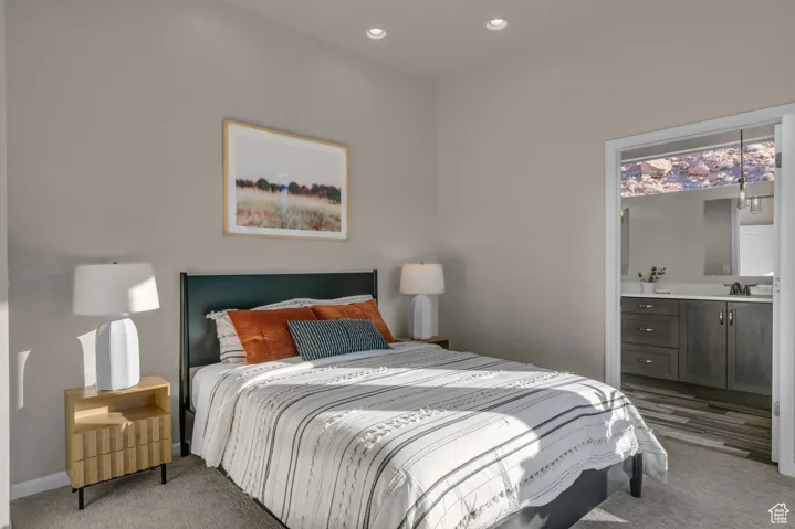 Bedroom featuring connected bathroom, light colored carpet, and recessed lighting