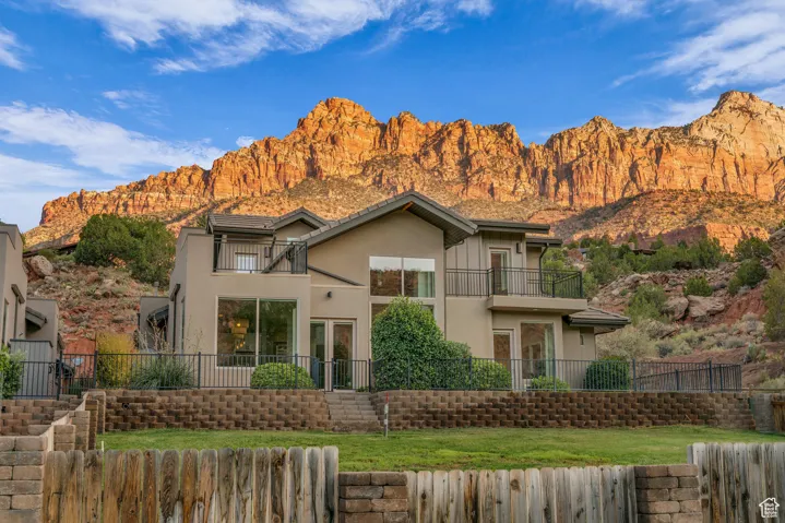 View of front of property featuring a balcony, stucco siding, and a mountain view