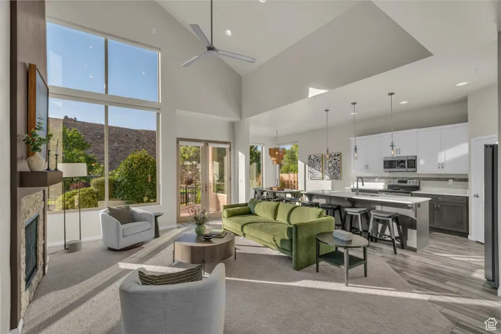 Living room with high vaulted ceiling, recessed lighting, a fireplace, french doors, and a mountain view