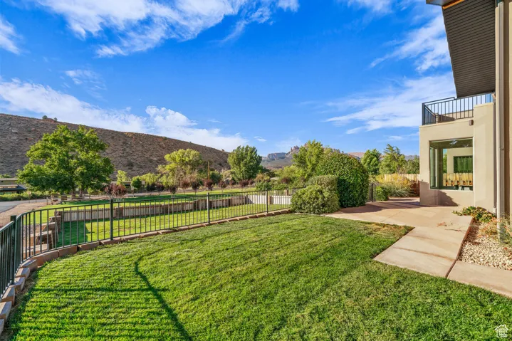 Fenced backyard featuring a patio area, a mountain view, and a balcony