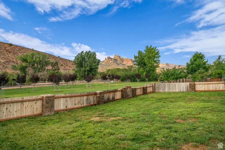 Fenced backyard with a view of countryside and a mountain view